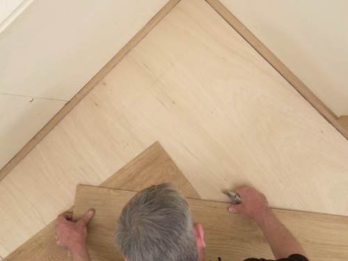 Installer cutting a loose lay plank at a 45 degree angle